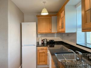 eine Küche mit einem weißen Kühlschrank und einer Spüle in der Unterkunft Ballygroggan Cottage - Uk48768 in Machrihanish