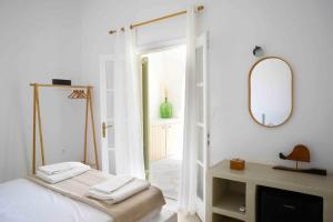a white room with a bed and a mirror at The endless blue experience in Ios Chora