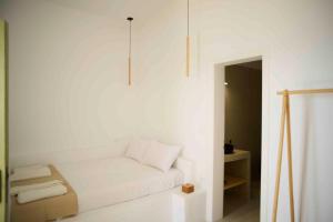 a white room with a couch and a chair at The endless blue experience in Ios Chora