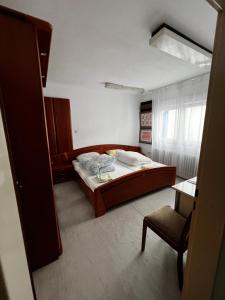 a bedroom with a large bed and a chair at TL Gastzimmer 1 in Frankfurt