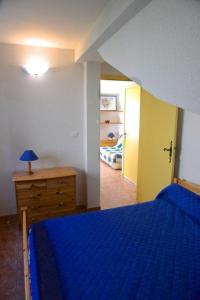 ein Schlafzimmer mit einem blauen Bett und einer Holzkommode in der Unterkunft Les myosotis in Bolquere