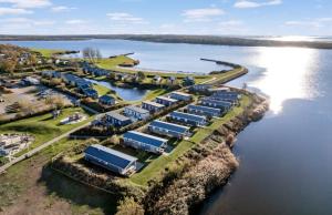 eine Luftansicht einer Gruppe von Fahrzeugen neben einem See in der Unterkunft Strandhuis `Meerzicht` in Lauwersoog
