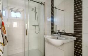 ein weißes Badezimmer mit Waschbecken und Dusche in der Unterkunft Strandhuis `Meerzicht` in Lauwersoog + 5 Fotos