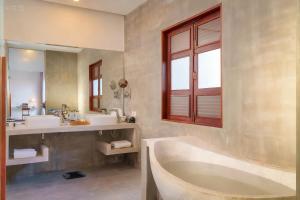 a bathroom with a tub and two sinks and a window at Gold Smith Residence in Siem Reap +29 photos