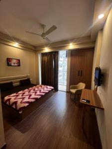 a bedroom with a bed and a table and a tv at street dream home stay omaxe itc Alpha 2 in Greater Noida