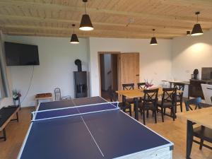 une table de ping-pong dans une pièce avec des tables et des chaises dans l'établissement Chalupa U Krtka, à Bělá pod Pradědem