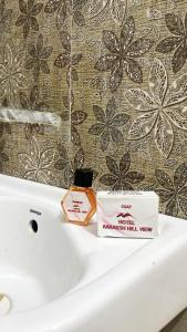 a bathroom sink with a soap and a box on it at Aakarsh Hill View Hotel in Rājgīr +37 photos