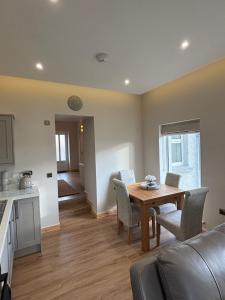 a living room with a table and chairs and a kitchen at Lighthouse View in Lochboisdale +8 photos