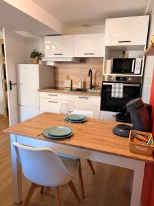 a kitchen with a wooden table with two plates on it at L'atelier du Charme Dole Centre in Dole +15 photos