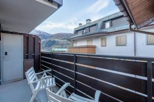 two chairs on a balcony with mountains in the background at La Casetta Vintage - Base Milan Cortina 2026 in Bormio