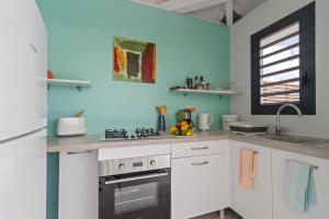 a kitchen with white cabinets and a stove top oven at Bungalow Lagoon in Fouché