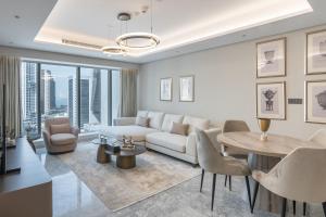 a living room with a white couch and a table and chairs at Thirty Five Westbay Luxury Apartments in Doha