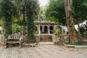 ein Haus mit einer Bank und Bäumen davor in der Unterkunft Lime Ahangama in Ahangama