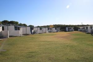 eine Reihe von Mobilheimen auf einem Grasfeld in der Unterkunft VIssershuisies at Grootvlei Guest Farm  + 19 Fotos