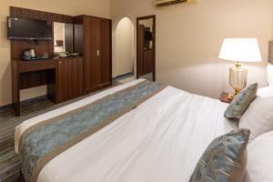 una habitación de hotel con una cama y un televisor en Snood Al Azizya, en La Meca 17 fotos más