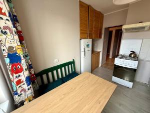 a small kitchen with a table and a refrigerator at Pokoje na Wichrowym in Poznań