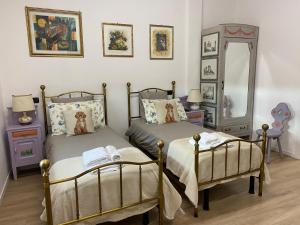 a bedroom with two beds and a mirror at CASCINA LAI - Oasi Naturalistica - Camere private in Santena