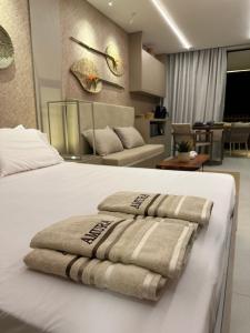 ein Schlafzimmer mit einem weißen Bett mit Handtüchern darauf in der Unterkunft Flat Amura Carneiros in Praia dos Carneiros + 39 Fotos