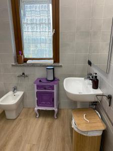 ein Badezimmer mit einem Waschbecken und einem lila Schrank in der Unterkunft CASCINA LAI - Oasi Naturalistica - Camere private in Santena + 18 Fotos