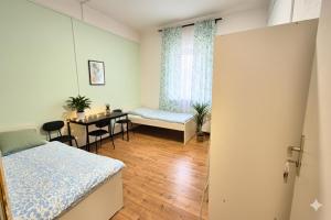 ein Schlafzimmer mit einem Bett und einem Tisch und einem Fenster in der Unterkunft L21-Apartment Flensburg, 5 Zimmer, 14 Betten, Standardisierte Ausstattung, ideal für Reisende, Pendler, Familien in Flensburg