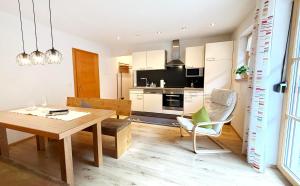 eine Küche und ein Esszimmer mit einem Holztisch und Stühlen in der Unterkunft Ferienwohnungen Anja in Steeg