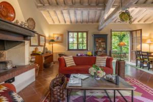 a living room with a red couch and a table at Casa Dell'Ambasciatore in Vivo dʼOrcia