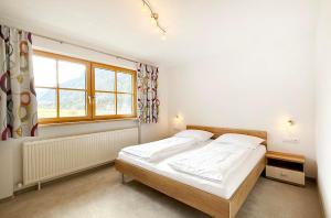 ein Schlafzimmer mit einem Bett und einem Fenster in der Unterkunft Ferienwohnungen Anja in Steeg