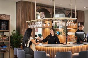 two people standing at a bar in a restaurant at Smarthotel Tromsø in Tromsø