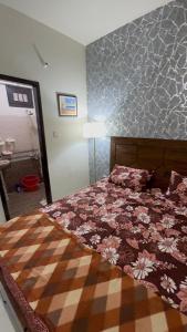 ein Schlafzimmer mit einem großen Bett mit einer Blumenbettdecke in der Unterkunft The Ultimate Beachfront Oasis in Karatschi