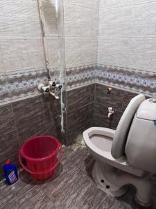 ein Badezimmer mit einem WC und einem roten Eimer in der Unterkunft The Ultimate Beachfront Oasis in Karatschi + 42 Fotos