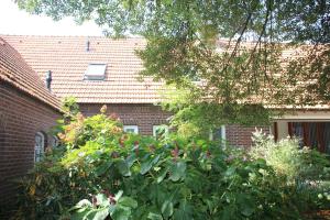 um grande arbusto em frente a uma casa de tijolos em B&B Even Heukelom - Kamer 4 em Afferden mais 2 fotografias