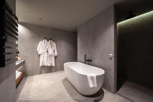 een badkamer met een groot wit bad in een kamer bij Villa Rossa Luxury & Spa Residence in Narechenski Bani +64 foto's