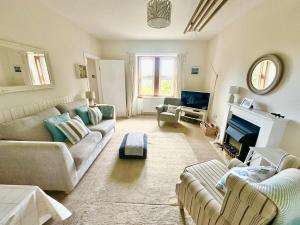a living room with two couches and a fireplace at Dunmore Cottage in Tarbert