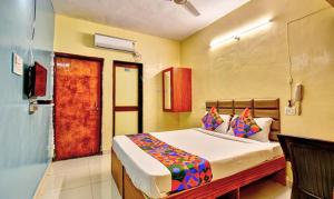 um quarto com uma cama e uma porta para um quarto em FabHotel SRH em Pune