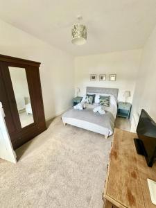 ein Schlafzimmer mit einem Bett, einem Tisch und einem Spiegel in der Unterkunft Dunmore Cottage in Whitehouse