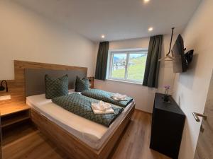 Un dormitorio con una cama grande con ventana. en Haus Schernthaner, en Saalbach Hinterglemm
