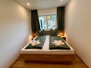Habitación pequeña con cama y ventana en Haus Schernthaner, en Saalbach Hinterglemm