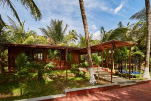 a house on the beach with palm trees at Sterling Anaikatti in Varagampadi