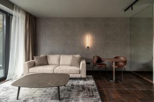 een woonkamer met een bank, een tafel en stoelen bij Villa Rossa Luxury & Spa Residence in Narechenski Bani