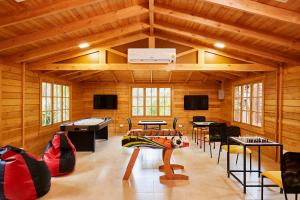 a large room with wooden walls and tables and chairs at Sterling Anaikatti in Varagampadi