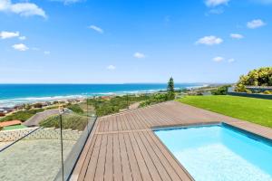 Outeniqua Strand31 Flamink Crescent Ave by Host Agents的甲板上的游泳池,背景是大海