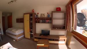 a room with a bedroom with a bed and a television at Erables 454 in Zinal