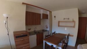 a small kitchen with a wooden table and a sink at Erables 454 in Zinal