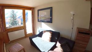 a living room with a couch and a window at Erables 454 in Zinal