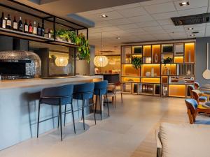 un bar dans un restaurant avec tabourets bleus dans l'établissement Ibis Florianopolis, à Florianópolis