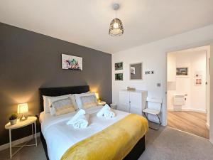 a bedroom with a large bed with two towels on it at The Post House One by Fortuna Property in Gloucester