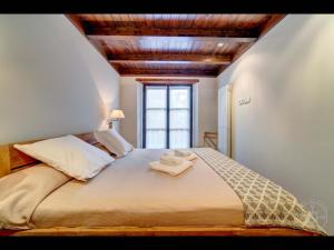 a bedroom with a large bed with two towels on it at Carreretes de Alma de Nieve in Barruera