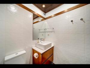 a white bathroom with a sink and a toilet at Carreretes de Alma de Nieve in Barruera +23 photos