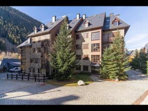 a large building with trees in front of it at Carreretes de Alma de Nieve in Barruera