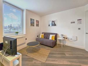 a living room with a couch and a tv at The Post House One by Fortuna Property in Gloucester